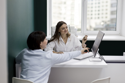 Zwei Frauen checken aktuelle Gesetzeslage am Computerbildschirm Zwei Frauen checken aktuelle Gesetzeslage am Computerbildschirm