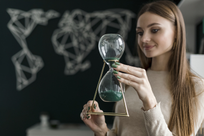 Junge Frau hält Sanduhr in den Händen. Junge Frau hält Sanduhr in den Händen.